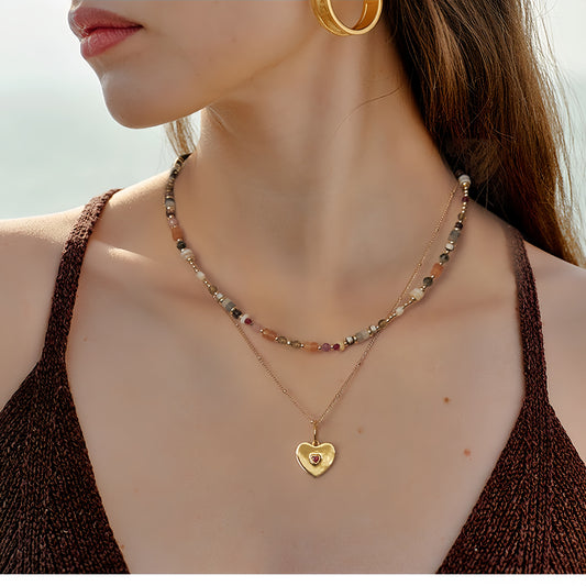 Layered heart pendant necklace with natural stone beads displayed on model, boho layered jewelry style