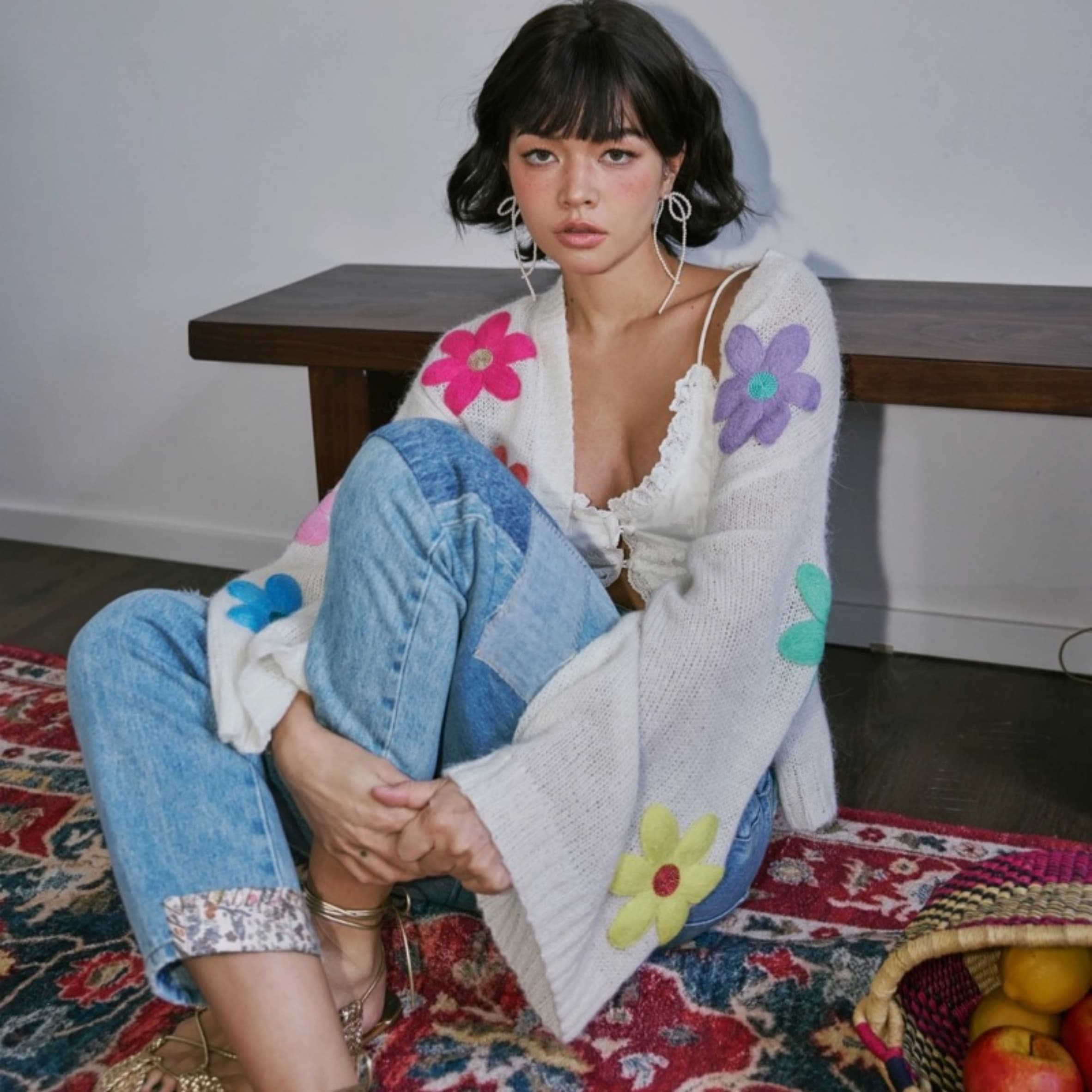 Trendy woman in floral knit sweater showcasing elegant earrings and minimalist necklace – modern fashion jewelry