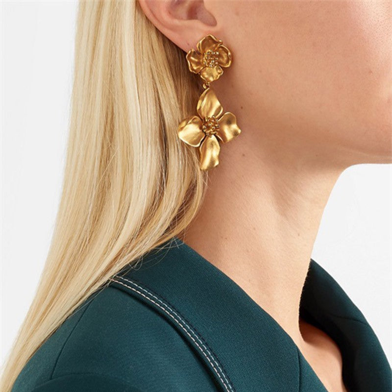 Gold floral statement earrings worn by model in elegant boho style